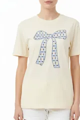 Remera blanca de manga corta y cuello redondo, confeccionada en algodón, con un diseño holgado y estampado frontal de estrella roja con textura y detalles de estrellas pequeñas.