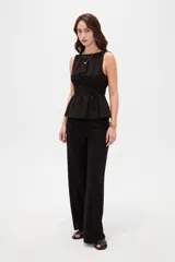 Top de lyocell color negro, sin mangas, con cuello redondo y diseño fruncido con elástico en la cintura que genera un corte peplum.