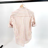 Camisa de lino a rayas verticales color tierra y blanco, con cuello mao y mangas largas con puños abotonados.