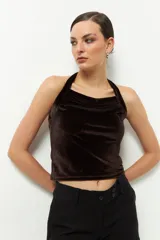 Top negro de terciopelo con escote halter, sin mangas y espalda descubierta.