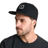 Gorra tipo snapback de cinco paneles con visera plana y ajuste profundo. Presenta un parche rectangular con el logo de la marca en el frente.