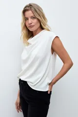 Blusa negra con pequeños puntos brillantes, cuello drapeado y mangas cortas.