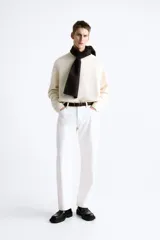 Cinturón de piel color marrón con costuras decorativas en los bordes. Presenta una hebilla metálica rectangular de color plateado y un pasador a juego.