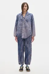 Camisa de jean oversized con lavado washed. Escote en V bajo con cuello camisero, mangas abullonadas.
