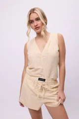 Musculosa color amarillo claro a rayas verticales blancas, con escote en V y corte recto.