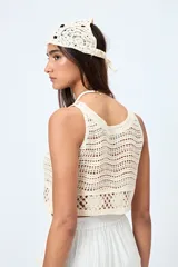 Top color crudo tejido al crochet, sin mangas y con cuello redondo.