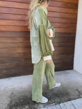 Polerón de corte holgado con mangas largas abullonadas, confeccionado en terciopelo negro con detalles en beige y blanco.