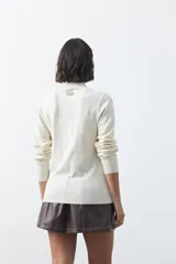 Polera de tejido de punto con cuello alto y diseño de rayas verticales sutiles. Presenta un ajuste al cuerpo y mangas largas.