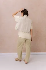 Chaleco de jean color crudo, con calce relajado y largo a la cintura. Cuenta con cuello camisero, cierre frontal con botones metálicos y bolsillos delanteros con tapa.
