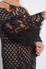 Vestido midi de encaje negro con forro color piel, hombros descubiertos y mangas acampanadas.