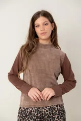 Polera de manga larga con diseño combinado, presentando un cuerpo de textura acanalada en tono marrón claro y mangas lisas en un tono marrón más oscuro. Posee cuello alto y corte recto.