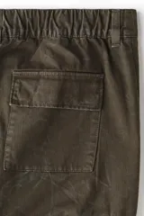 Pantalón cargo de sarga de algodón con efecto lavado, corte relajado, cierre frontal con botón, bolsillos laterales tipo cargo con solapa y bolsillos traseros.