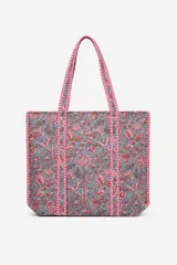 Bolso tipo tote con estampado floral en tonos rosados sobre fondo gris, con correas y bordes reforzados con cinta a rayas rojas y blancas.