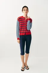 Chaqueta de punto con cuello redondo y mangas largas, con diseño de rayas horizontales en colores rojo, celeste y azul marino, y cierre frontal con botones.