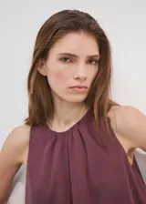 Vestido corto bordó con diseño de capas y volantes, escote redondo y tirantes anchos.