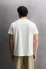 Camiseta de corte relajado confeccionada en tejido de algodón pesado, con cuello redondo y manga corta.