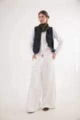 Pantalón de jean con diseño de tiro medio-bajo y piernas anchas. Presenta una pretina ancha con cierre de tres botones metálicos frontales, pinzas decorativas en la cintura y bolsillos delanteros funcionales.