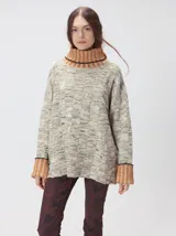 Pullover de punto jacquard color tostado con cuello alto y puños acanalados en tono azul y detalles en naranja. Cuenta con aberturas laterales y calce holgado.