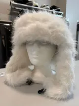 Gorro estilo ruso de piel sintética en color blanco, con diseño de orejeras y cierre mediante clip ajustable.