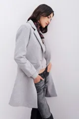 Tapado de paño gris con apliques de hotfix plateados. Presenta un diseño de corte regular con cuello solapa, cierre frontal con botón, bolsillos laterales con tapa y forrería interna a tono.