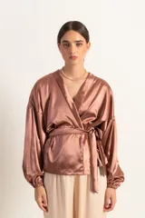 Kimono corto color marrón cobrizo de satén, con mangas globo con elástico en los puños y lazo para atar en la cintura.