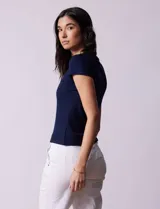 Remera color beige de tejido acanalado, con escote a la base y manga corta.