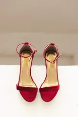 Sandalia de tacón cuadrado medio, confeccionada en tela tipo terciopelo color bordó, con tira delantera simple y pulsera ajustable al tobillo con hebilla metálica.