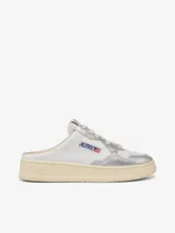 Zapatilla Mule Autry de cuero blanco con puntera plateada brillante y cordones grises.