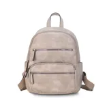 Mochila color marrón claro de símil cuero con bolsillos frontales con cierre. Tiene asa de mano rígida y correas regulables.