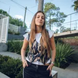 Chaleco corto con estampado abstracto en tonos dorados y azules, escote en V y cierre frontal con botones de madera.