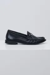 Mocasín negro de cuero con textura tipo cocodrilo, detalle de estribo metálico plateado en el empeine y costuras reforzadas en la puntera.