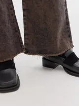 Jean de corte flare y tiro medio con acabado de lavado ácido (acid wash) y ruedo desflecado sin costura.