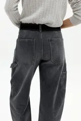 Pantalón de denim con corte barrel relajado y tiro medio, confeccionado en algodón con spandex. Presenta un estampado floral integral sobre fondo negro.