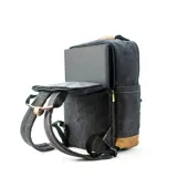 Mochila matera y porta notebook en tela canvas de color marrón, con diseño funcional que incluye bolsillo frontal con cierre, correas ajustables, manija superior y detalles de tiras de lona con hebillas metálicas.