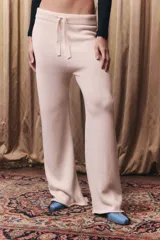 Pantalón de tejido de punto color off white, de corte recto y holgado. Presenta cintura elástica con cordón de ajuste y acabado en rib.