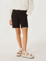 Bermuda negra de tiro medio confeccionada en sarga de algodón y elastano, con diseño tipo chino y corte casual.