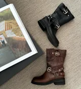 Bota de cuero vacuno color negro, con hebillas ajustables, cierre interno y suela de goma artesanal.