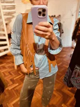 Chaleco de cuero vacuno color marrón claro con flecos largos en el frente.