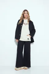 Canguro negro de silueta relajada con capucha, bolsillo canguro y estampados gráficos blancos en el pecho y las mangas.