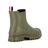 Bota de lluvia de caña corta color rosado, confeccionada en material impermeable con suela track dentada. Presenta un parche decorativo con letras en el frente y una tira de agarre tricolor en la parte posterior.