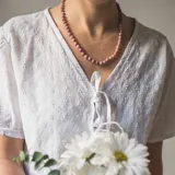 Collar de cuentas de piedra Rodocrosita rosada de 6mm, con separadores de hilo color salmón y cierre mosquetón dorado de acero hipoalergénico.