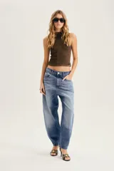 Jean slouchy de tiro alto confeccionado en 100% algodón con silueta tipo barrel y lavado celeste.