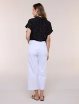 Pantalón capri blanco de corte recto y largo crop, con cintura alta y bolsillos delanteros aplicados estilo parche con detalle festoneado.
