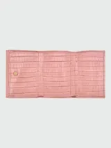 Billetera compacta de cuero con textura de cocodrilo en color rosado, con cierre de botón a presión dorado y múltiples ranuras para tarjetas.