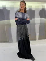 Falda larga plisada color marrón con estampado geométrico dorado en la parte superior y bolsillos laterales.