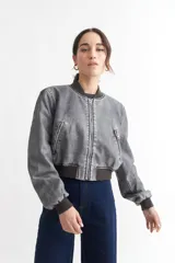 Campera bomber gris de cuero sintético con cuello, puños y ruedo acanalados.