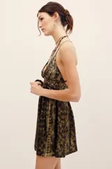 Vestido corto de poliéster con estampado animal print tipo piel de serpiente en tonos marrones y dorados. Presenta escote en V pronunciado, tirantes finos y detalle de argolla metálica en el centro del busto.