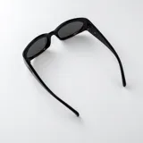 Lentes de sol con armazón carey y diseño envolvente, cuentan con filtro UV400 y patillas anchas con detalle ovalado metálico.