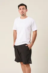 Bermuda deportiva de nylon color gris, de corte suelto, con cintura elástica y cordón de ajuste. Cuenta con detalles de líneas negras en los costados y bolsillos laterales con cierre.