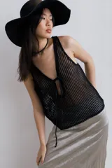 Top de red calada color negro, sin mangas, con escote en V y lazo ajustable en el centro.